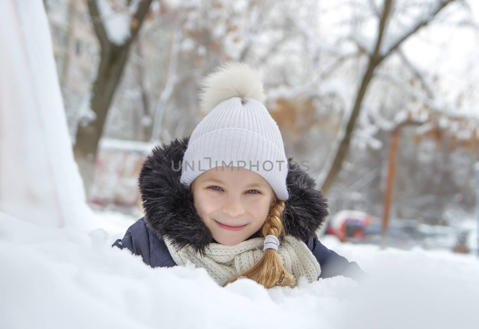 Girl playing lying in snow at winter park by Angel_a