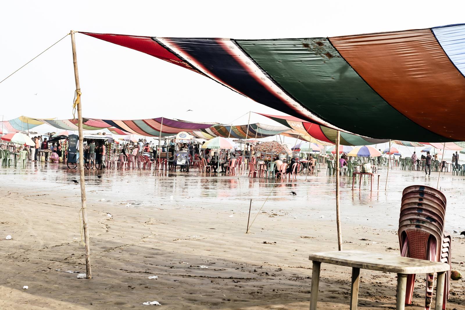 Versova beach, Mumbai India 10, Jan 2019: Beach market View of crowded with tourists and vendors in during new year festival, causes water pollution due to plastic and pile of garbage.