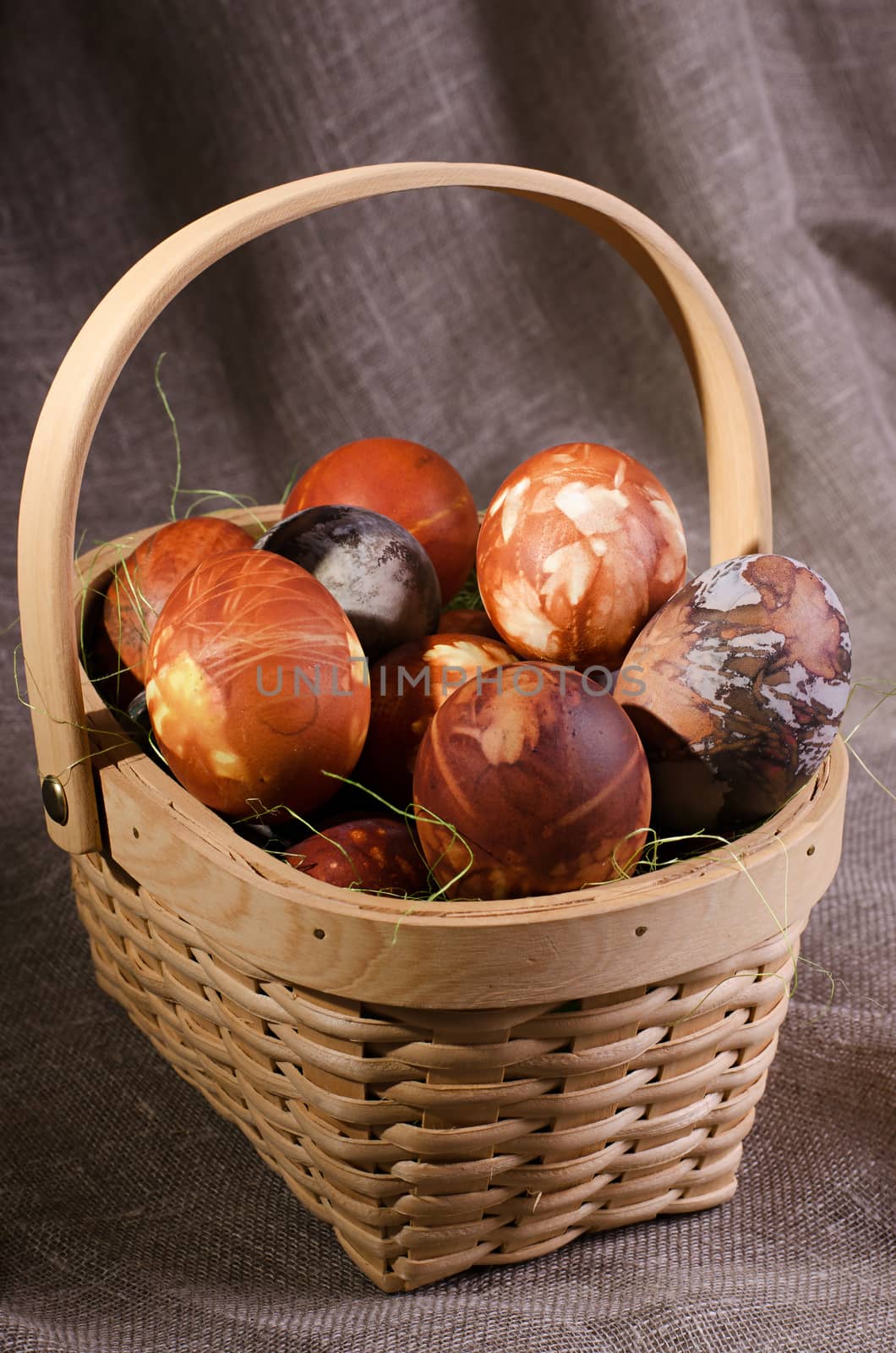 Easter eggs. Brown painted eggs in the basket on brown background.