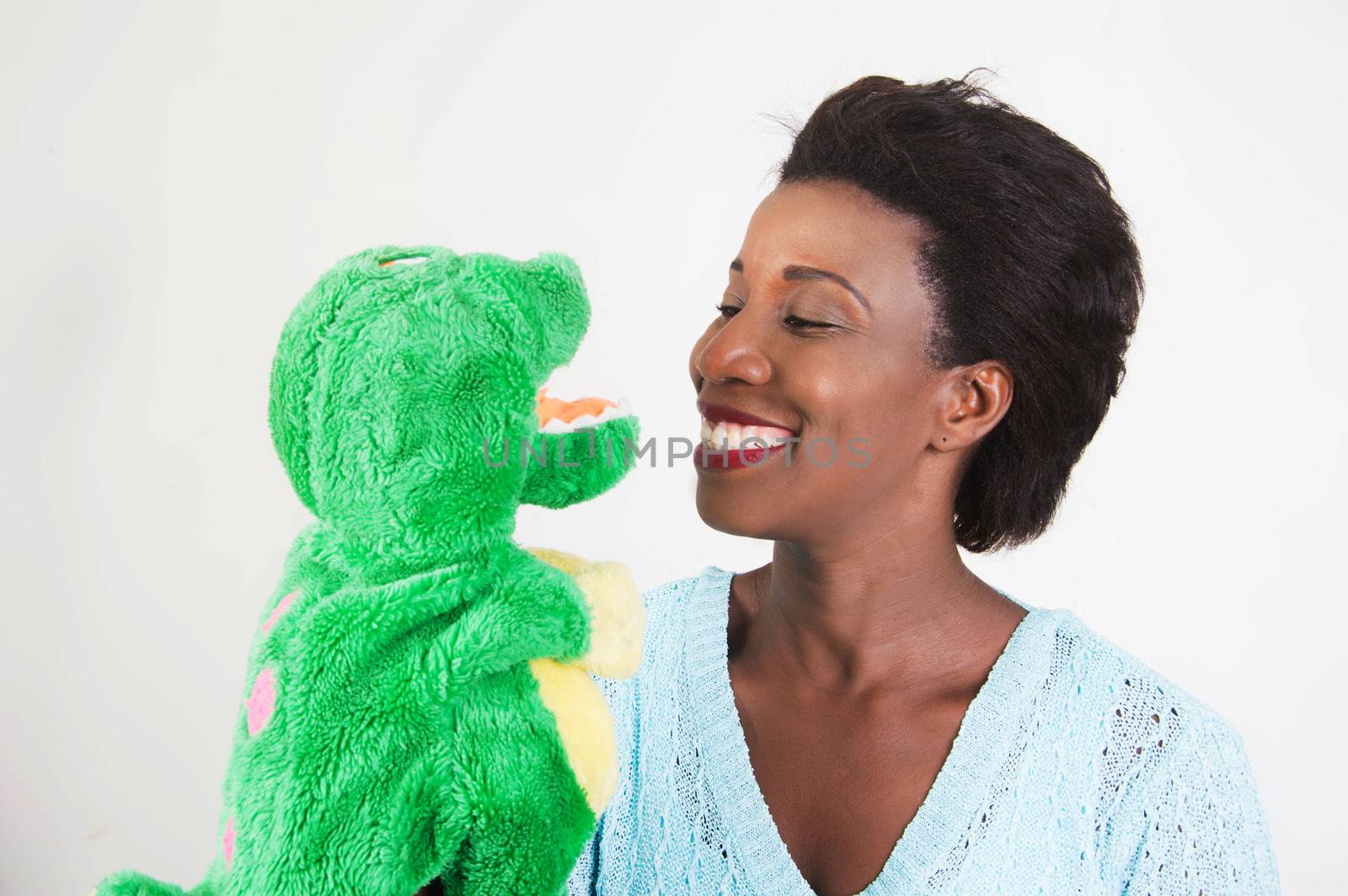 young woman draws attention to her child on the toy that fits in the hand.