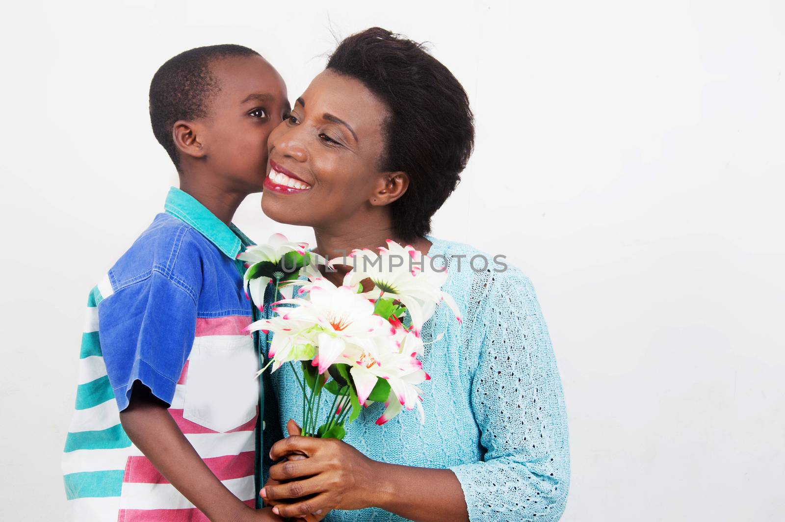child wishes good mothers day to his mother by offering her a flower.