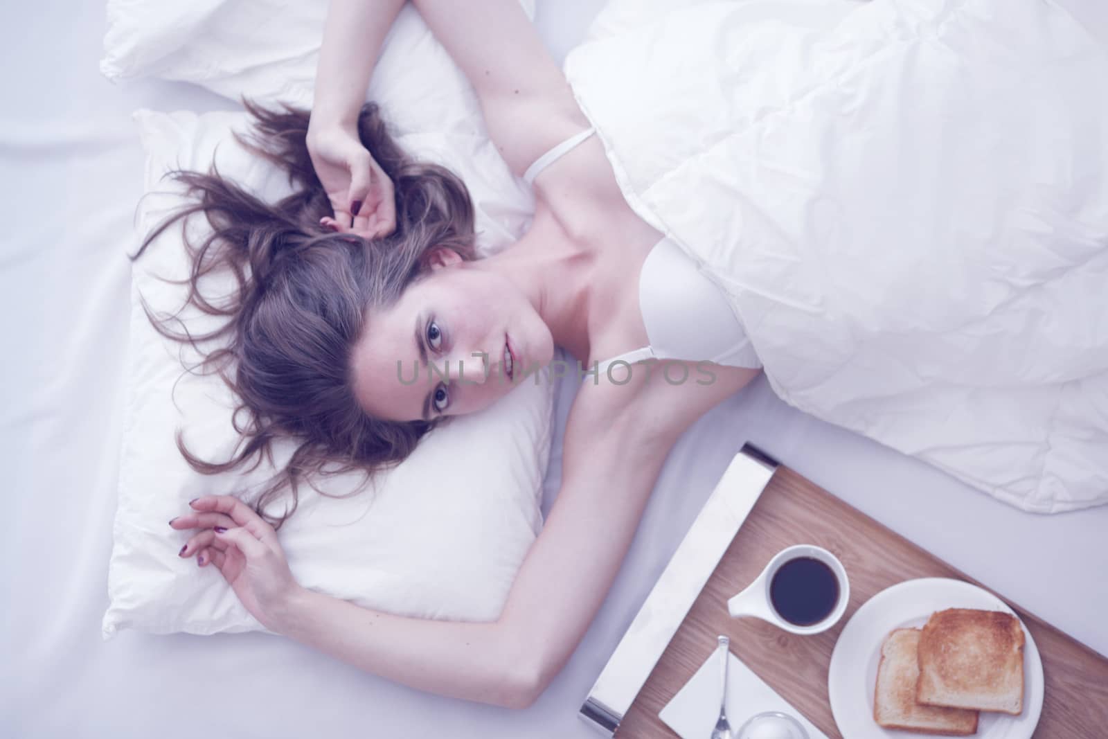 Woman having breakfast in bed by ALotOfPeople