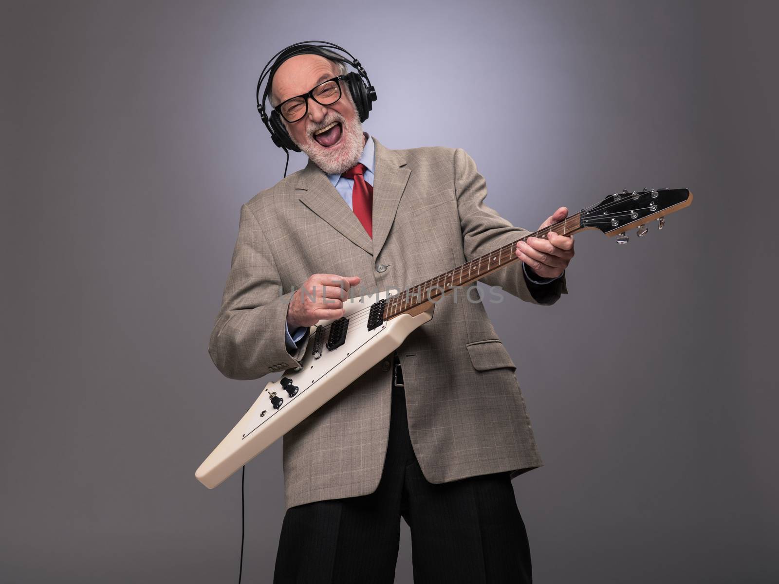 Senior man playing electric guitar by ALotOfPeople