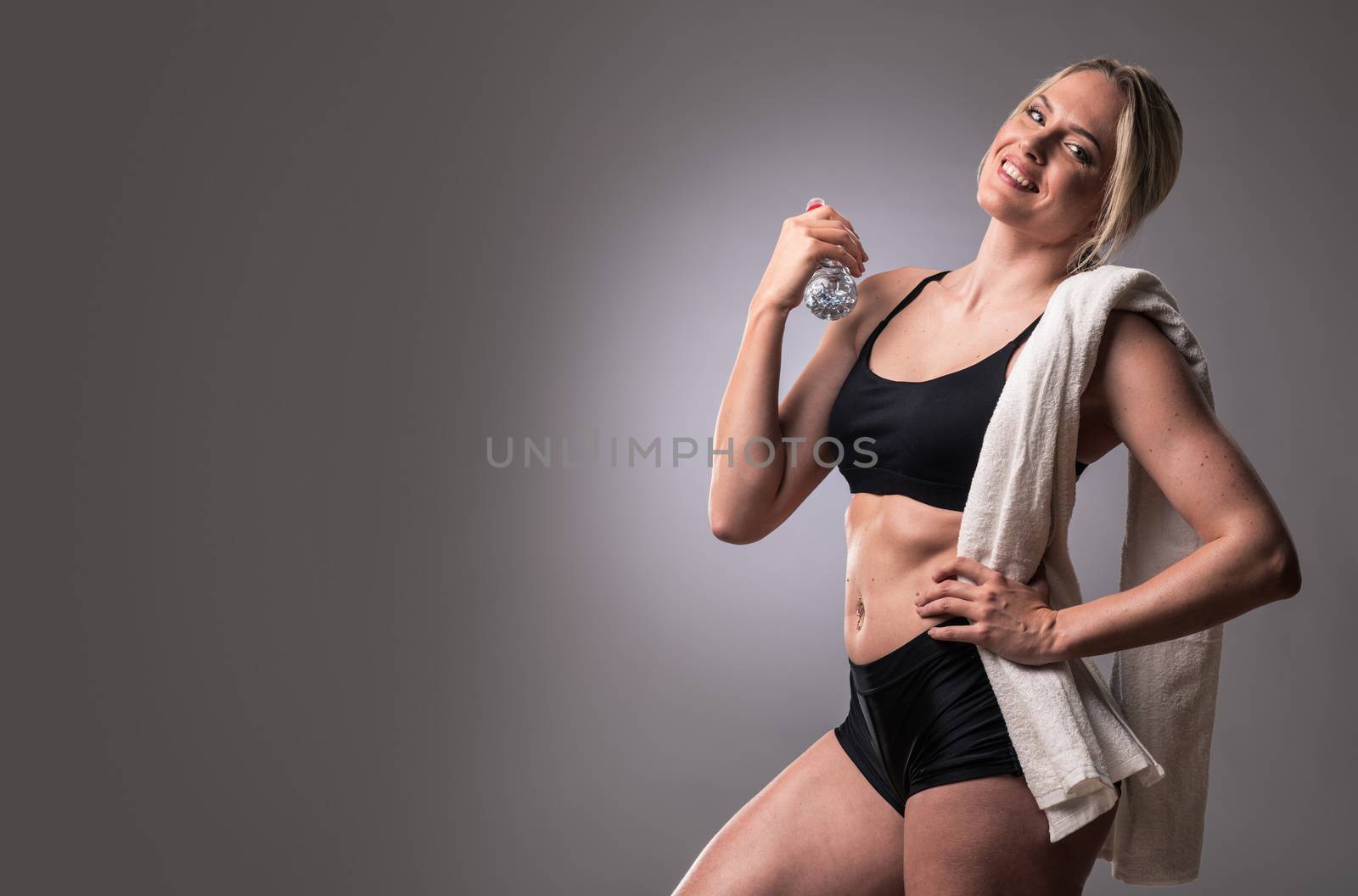 Muscular woman with towel after gym workout