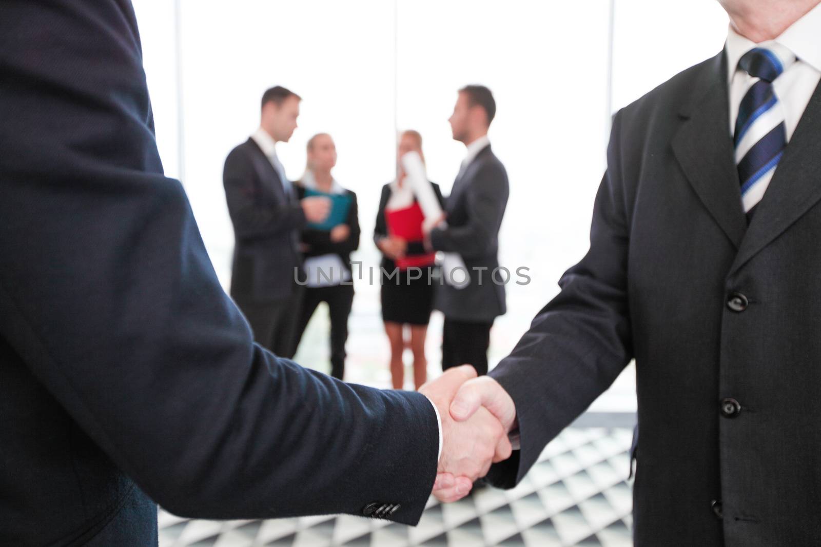 Business people shaking hands, finishing up a meeting in office