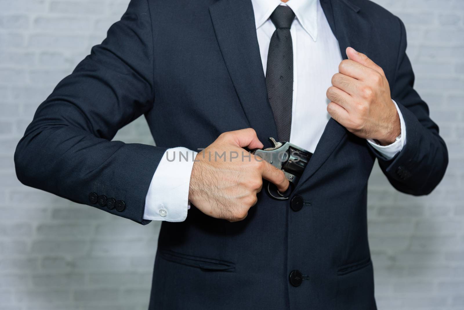 businessman with gun on gray background