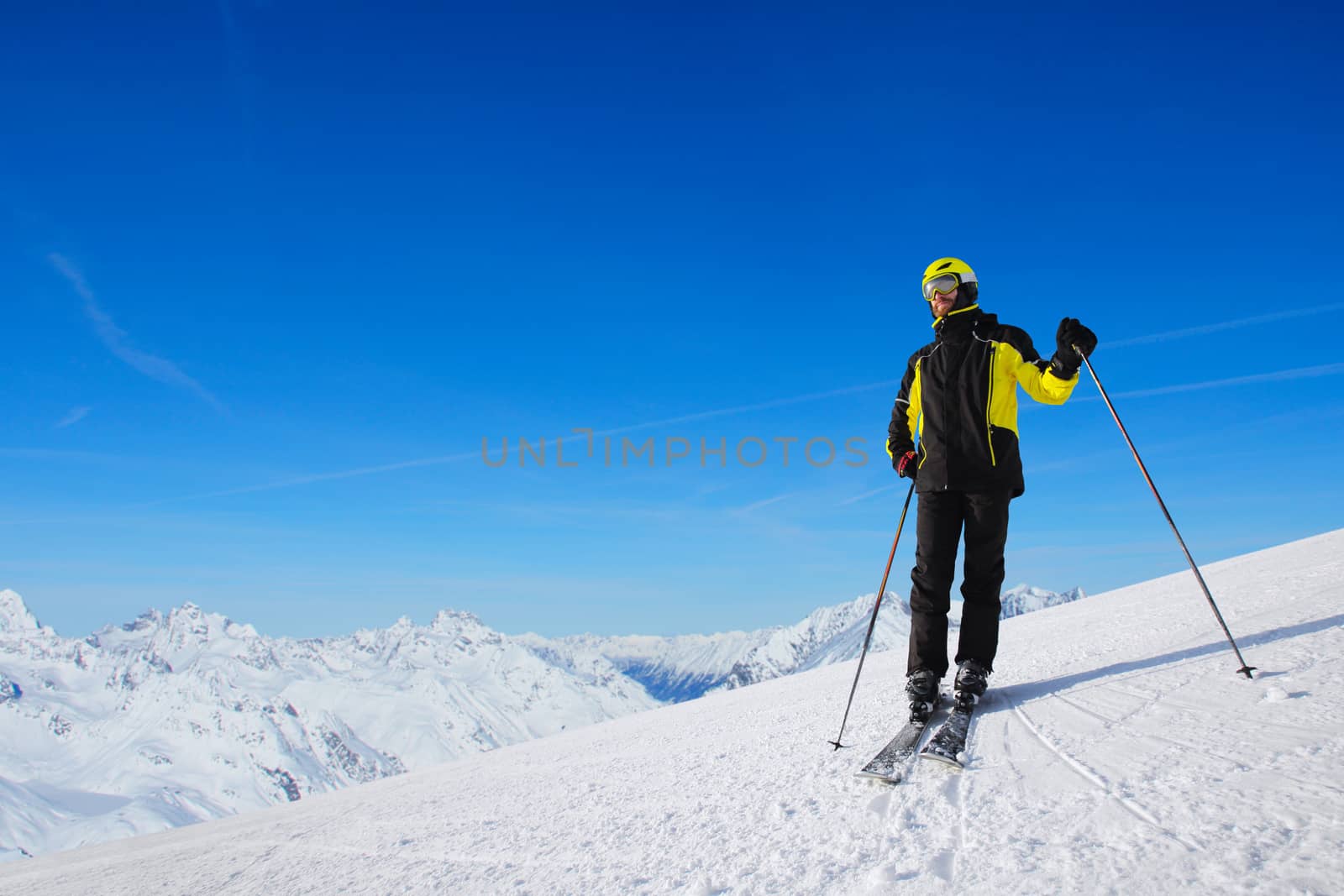 Skier standing alone and looking at panoramic view at Alps mountains