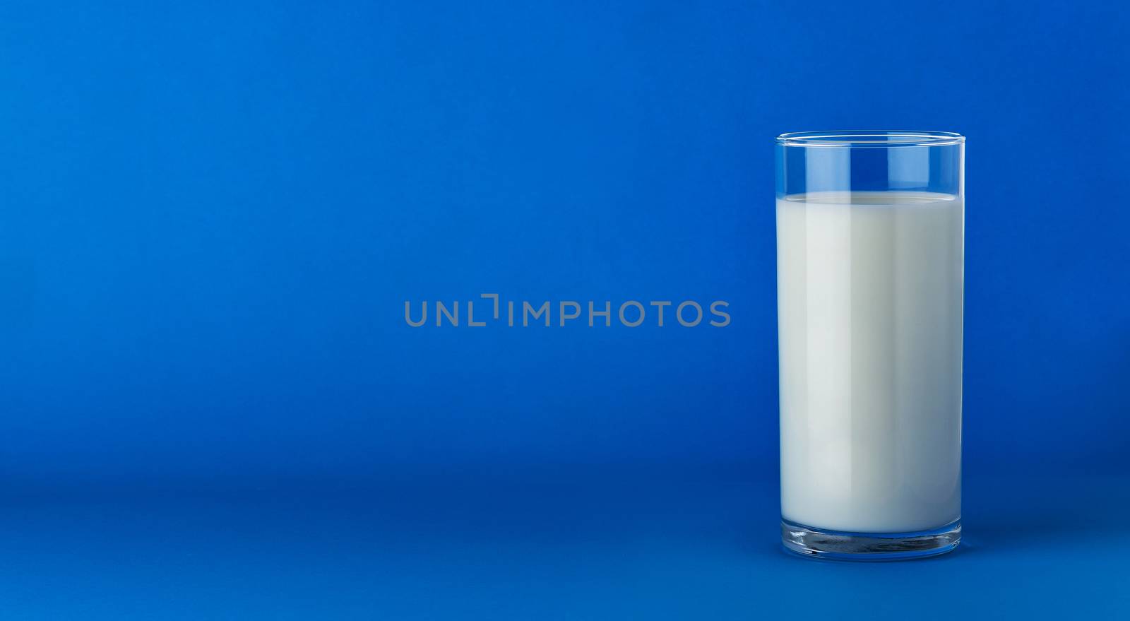 Glass of milk isolated on blue background with copy space by xamtiw