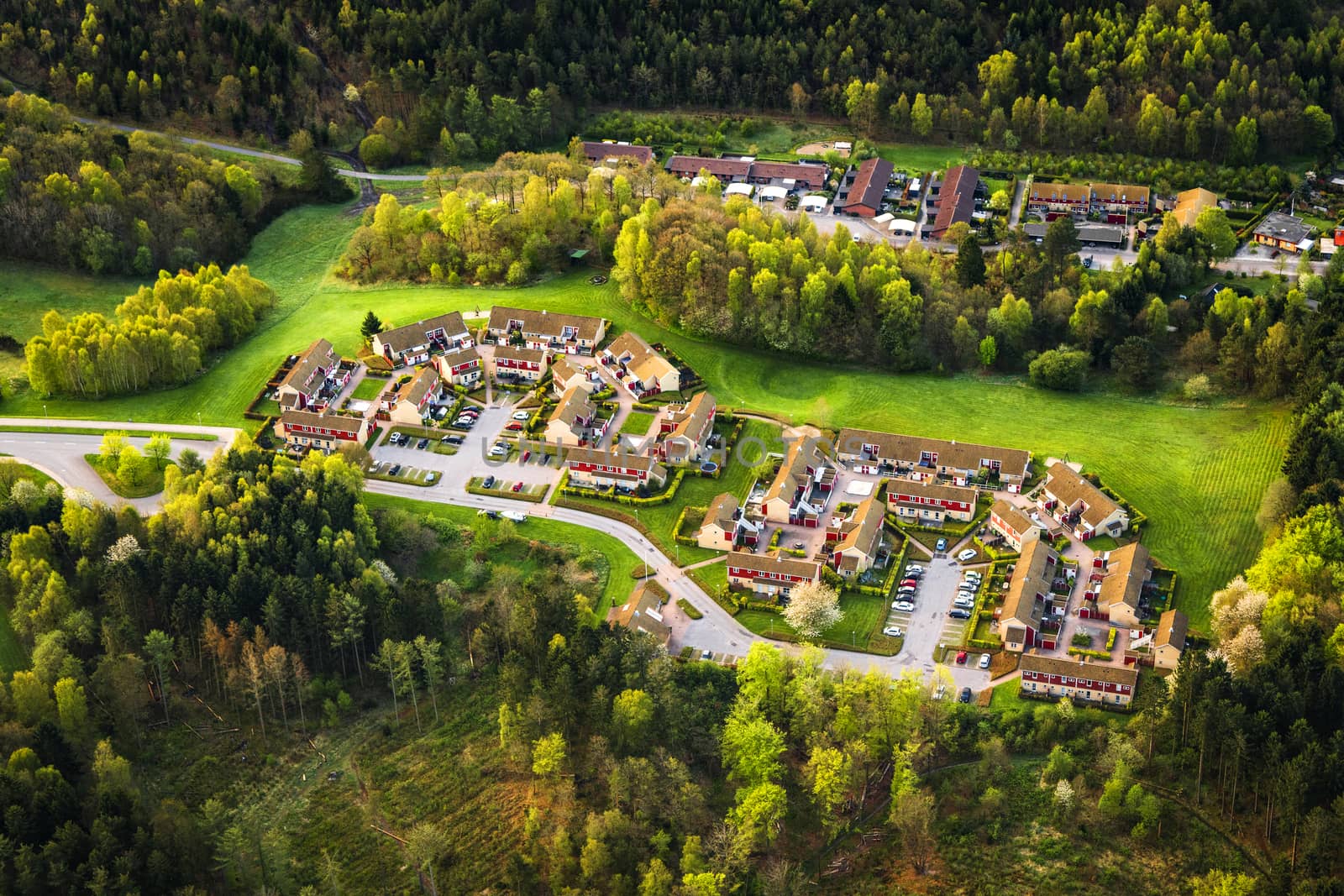 Small village seen from above surrounded by forest on a sunny day