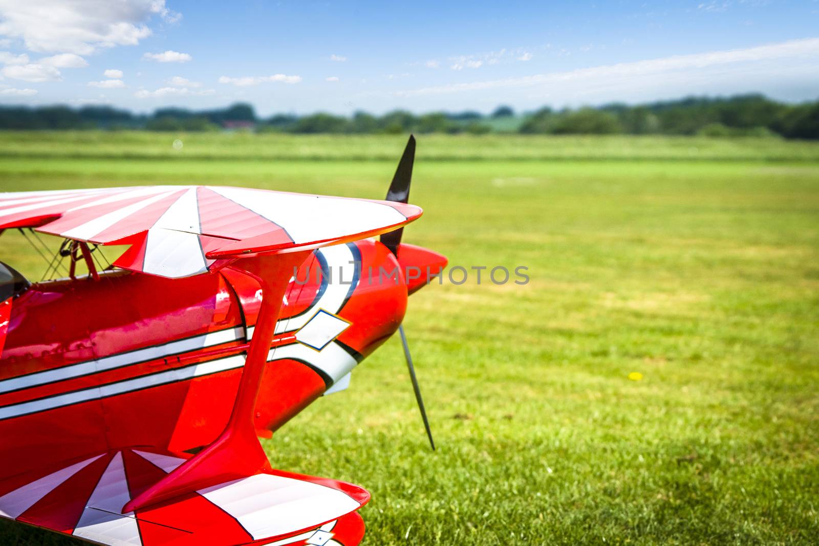 Retro airplane ready to take of on a green field in the summer