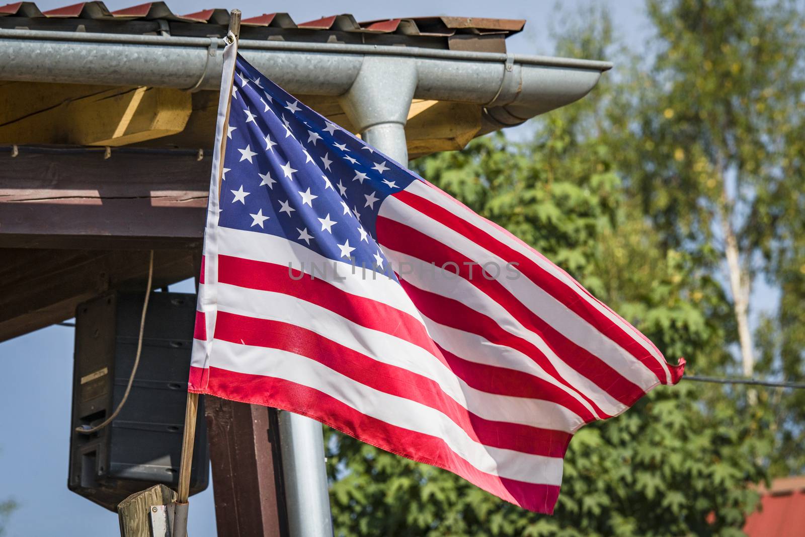 American flag on a porch outside a small cabin by Sportactive