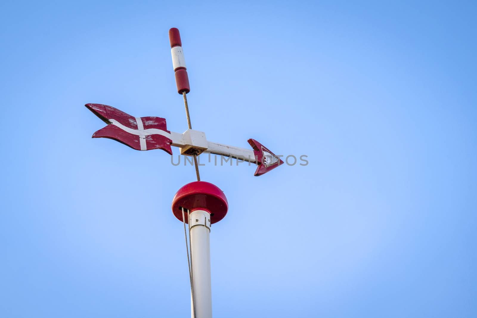Danish weather vane with the flag of Denmark and an arrow sign pointing right