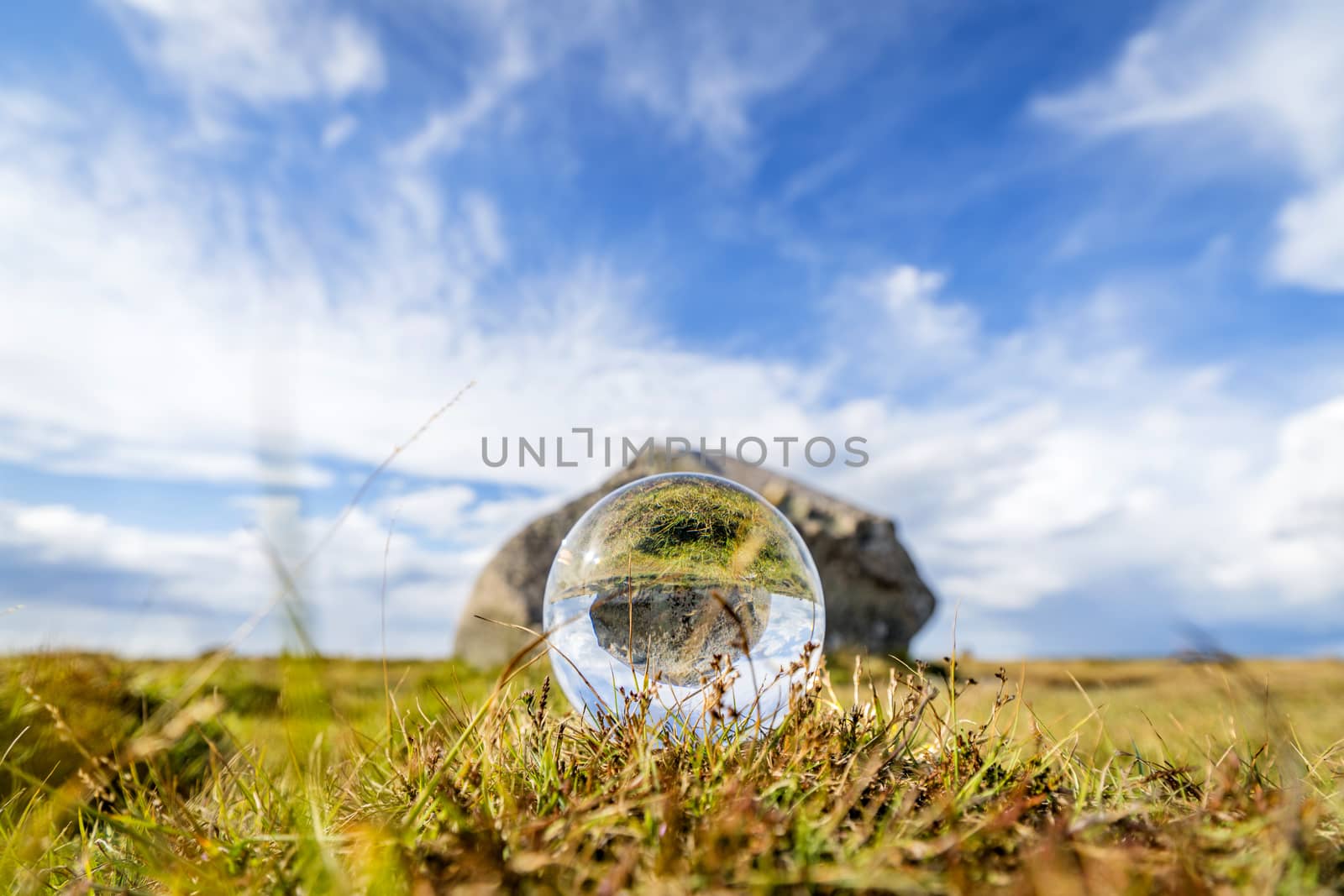 Glass orb on grass with reflection by Sportactive