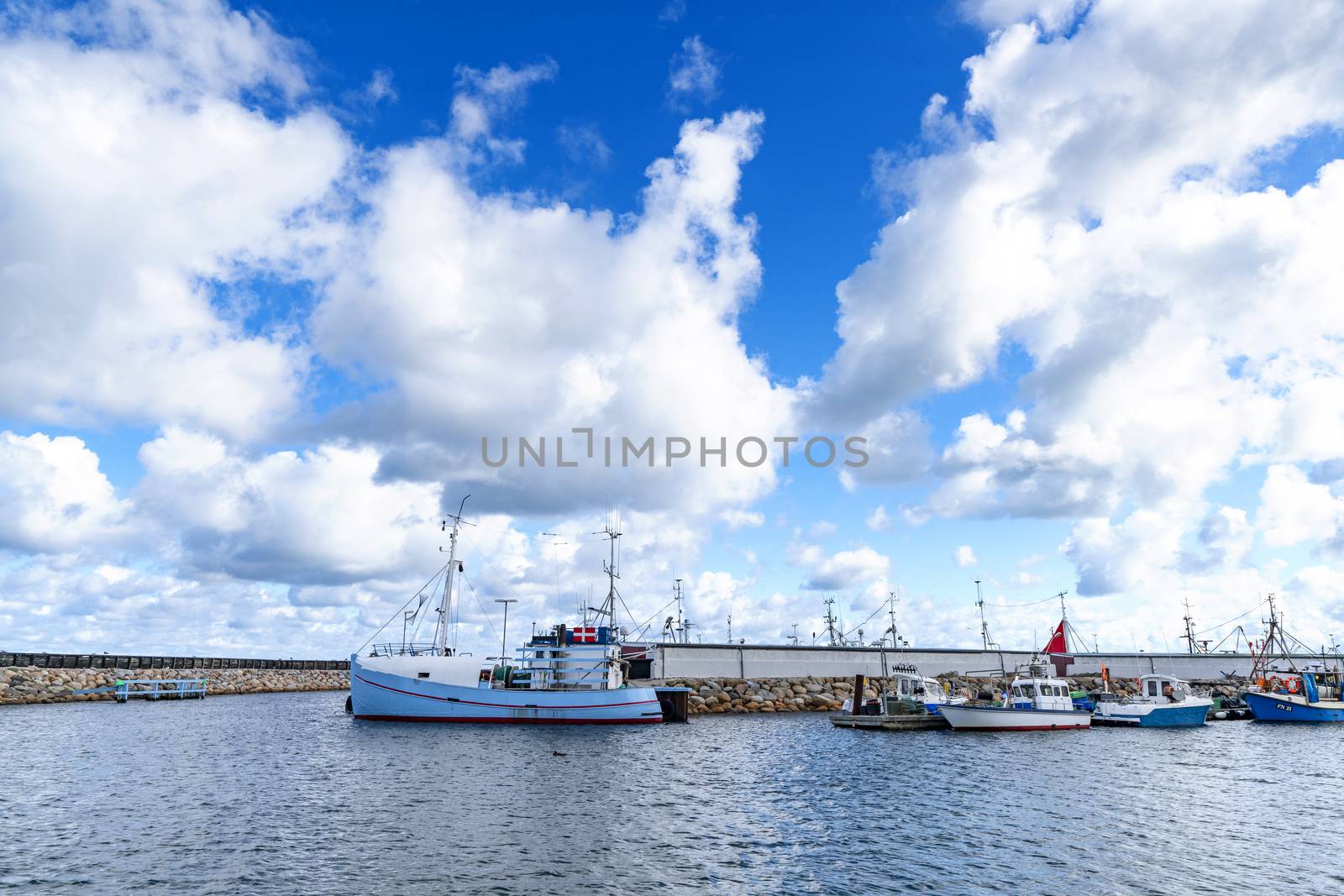 Fishing boats in a harbor in Denmark under a blue sky in the summer