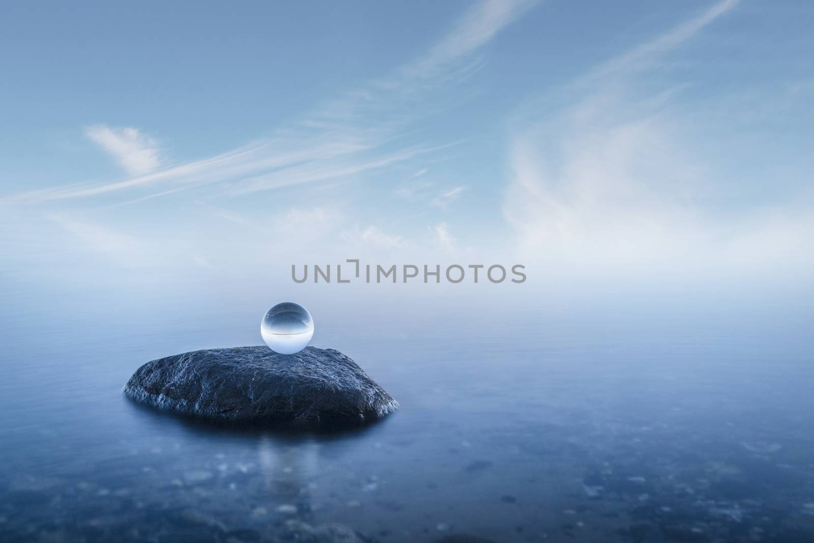 Crystal ball on a rock in a misty seascape by Sportactive