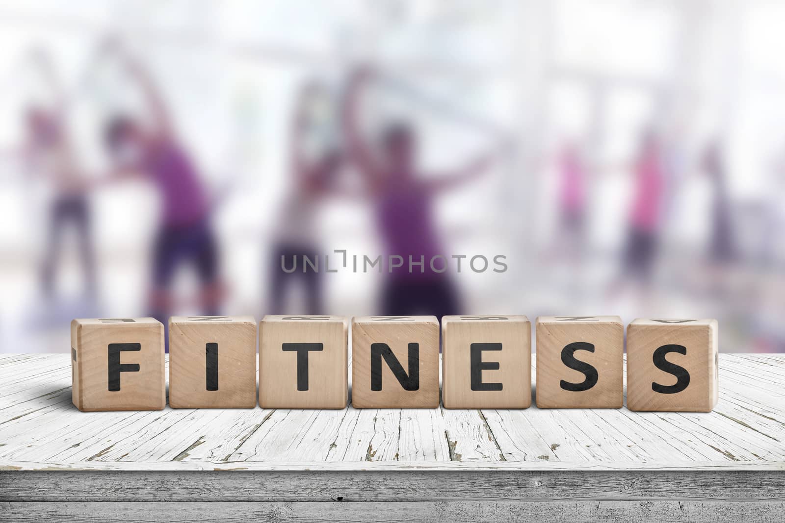 Fitness sign on a table in a gym with women training in the background