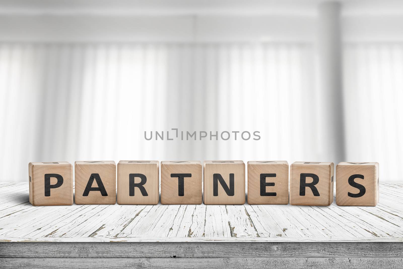 Partners sign on a desk in a bright office with white curtains in the background