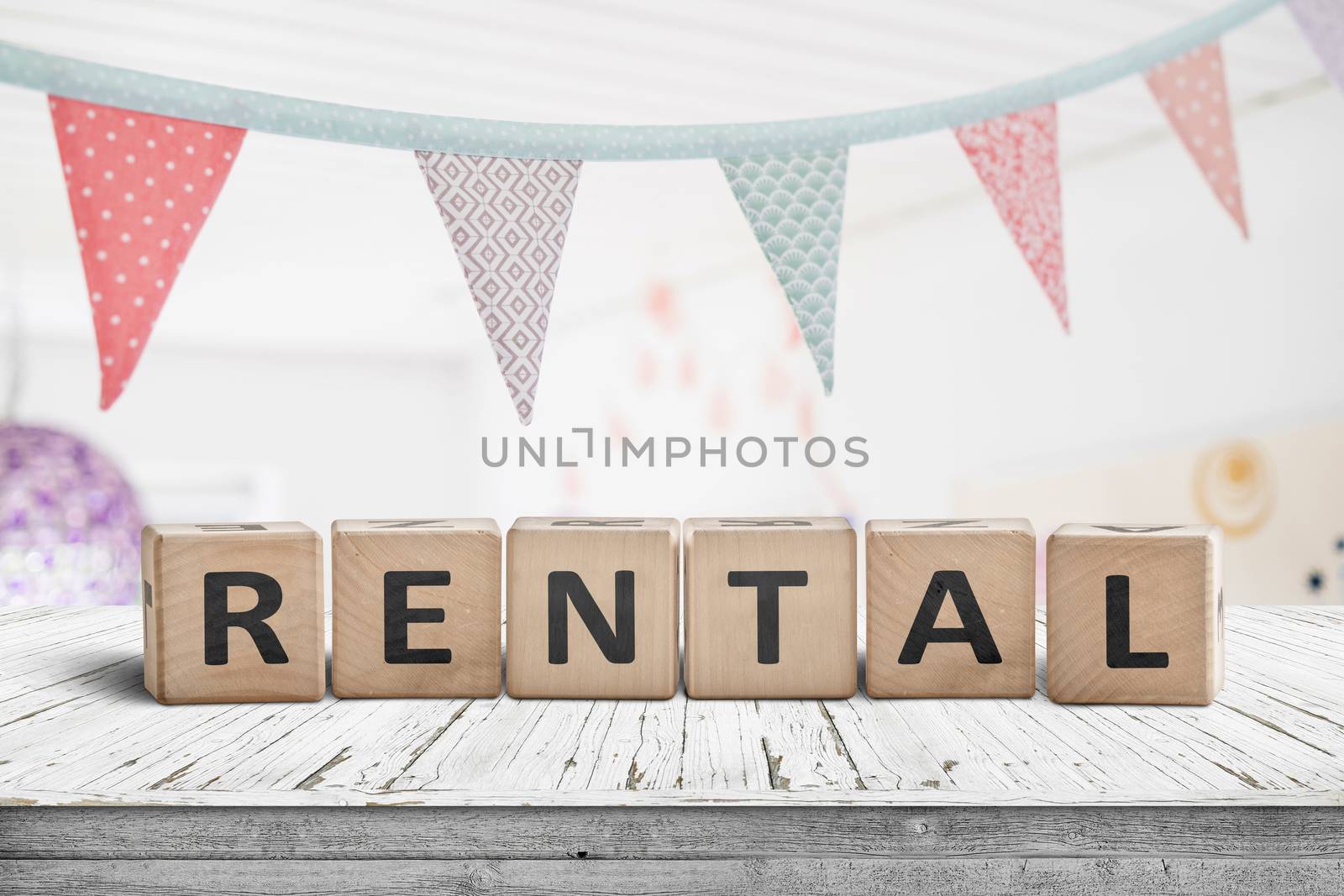 Rental sign with flags hanging over a wooden desk in a bright room