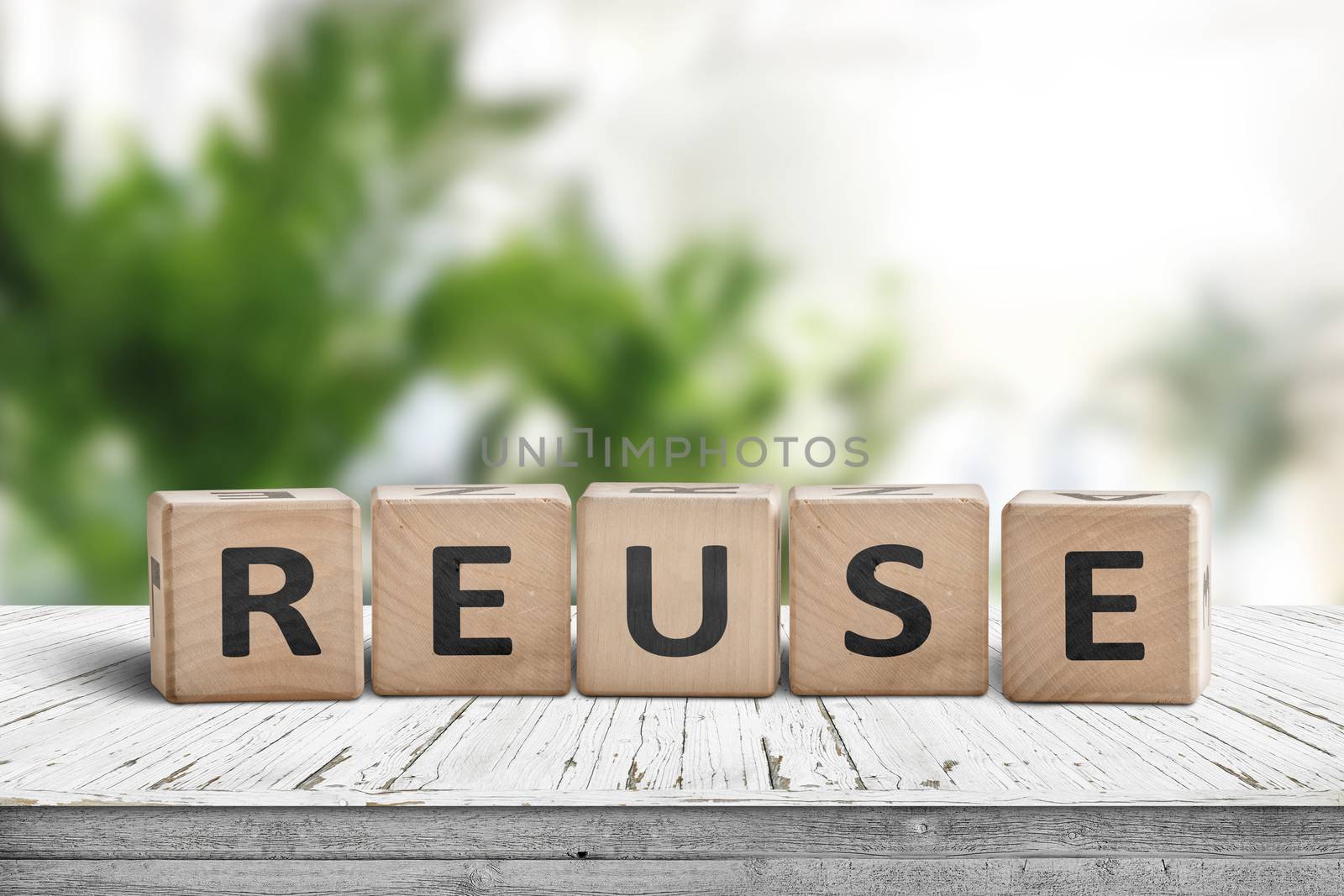 Reuse sign on a wooden table in a room with green plants in bright light