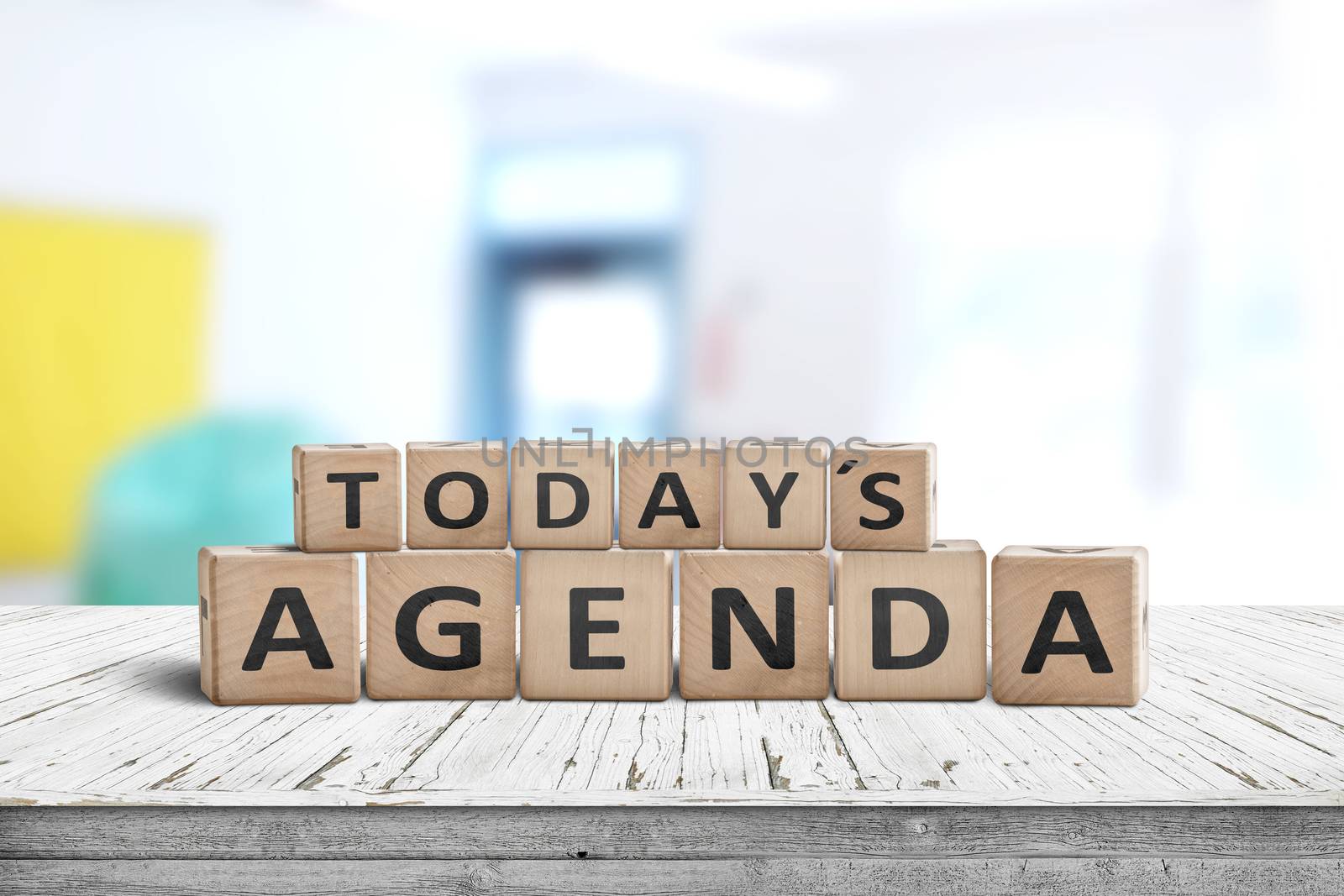 Today's agenda sign on a wooden desk in a bright classroom with colors