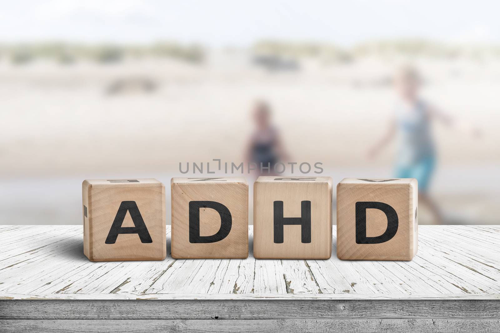 ADHD sign on a wooden table with kids acting wild in the background