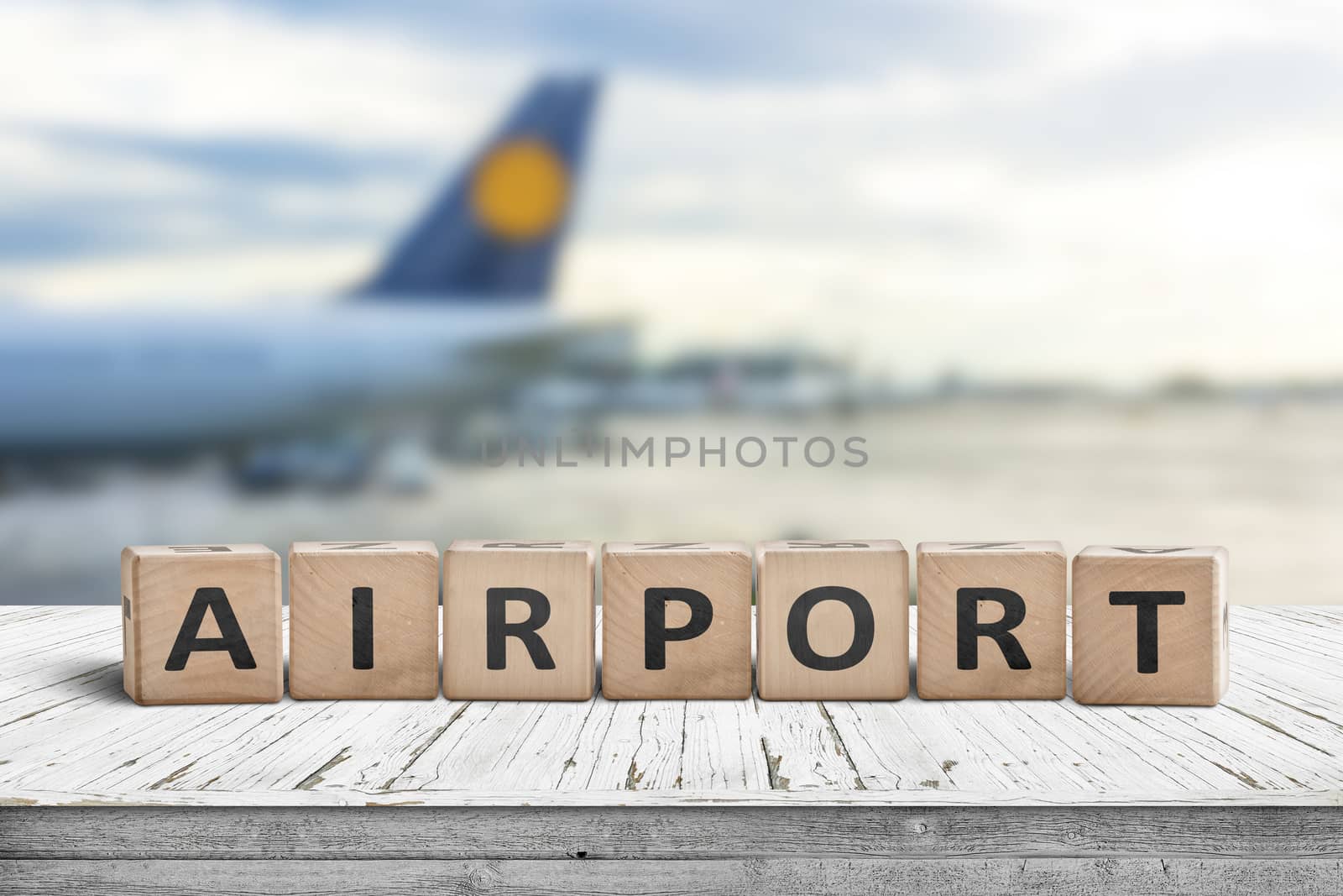 Airport word sign on a wooden surface with a plane in the background