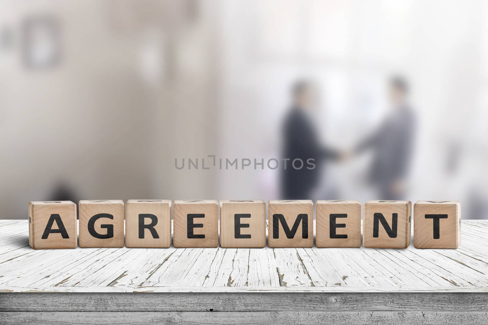 Agreement sing on a word with business men shaking hands in the background