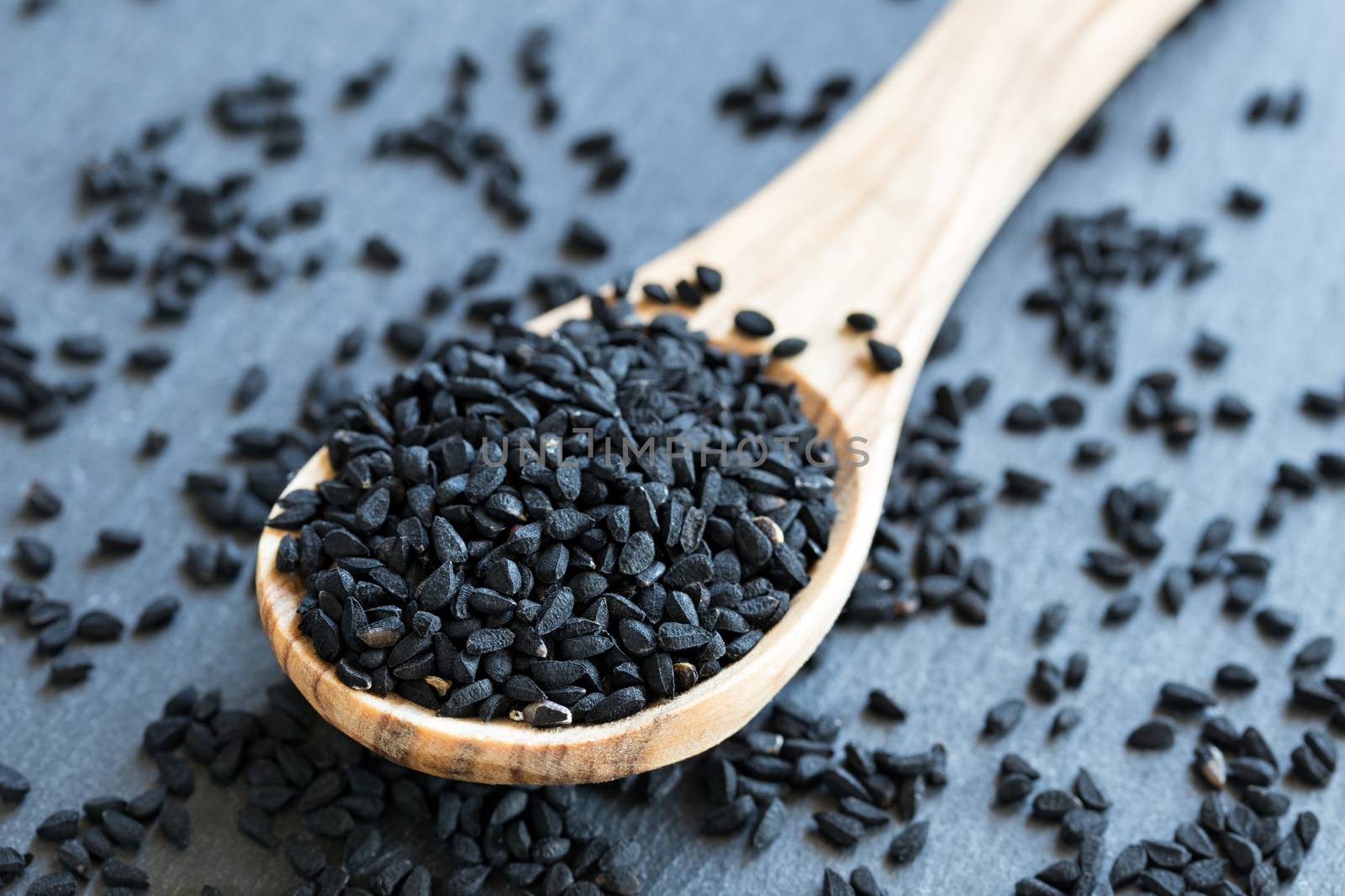 Black cumin seeds on a wooden spoon