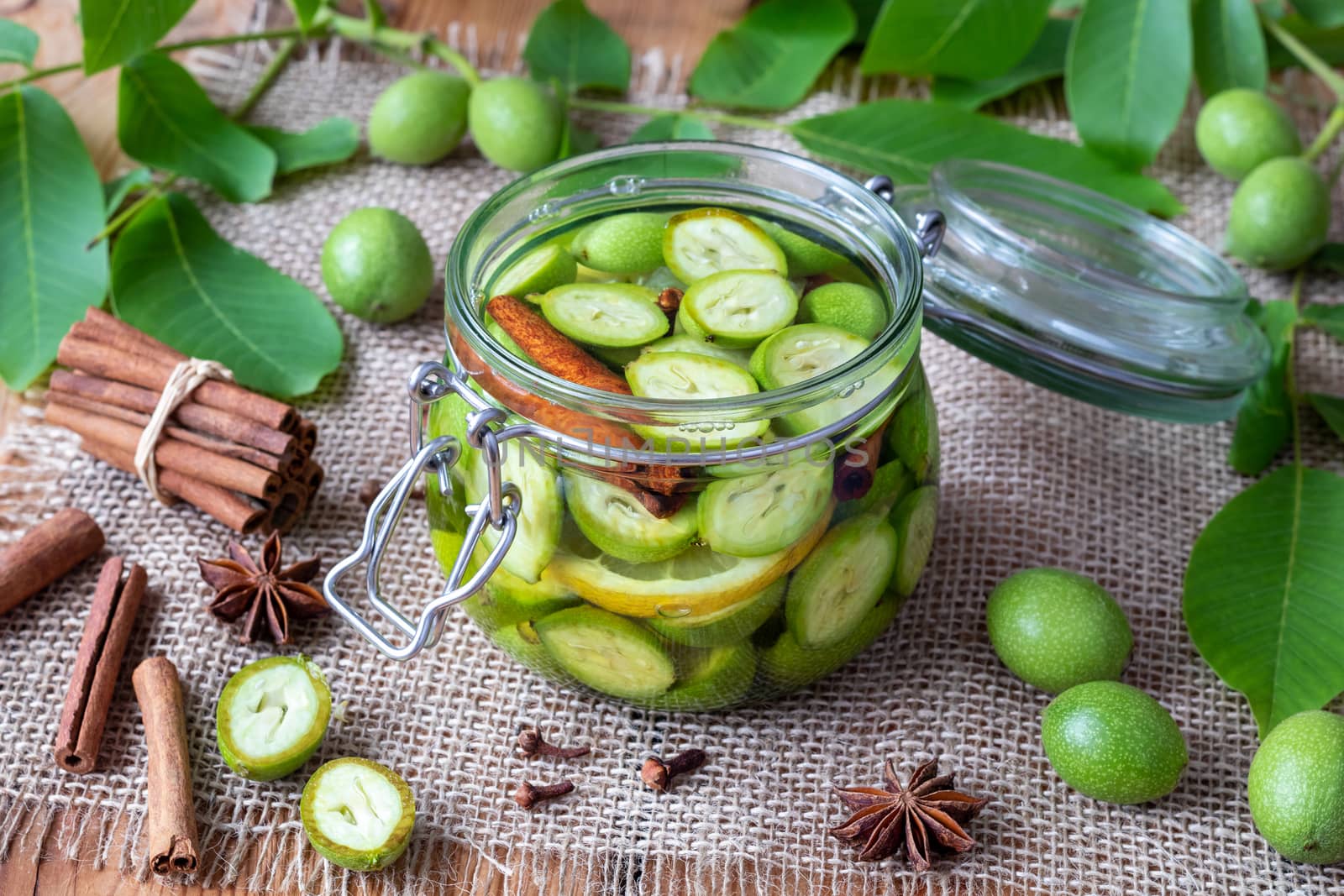 A glass jar filled with unripe walnuts, alcohol and spices, to prepare homemade tincture