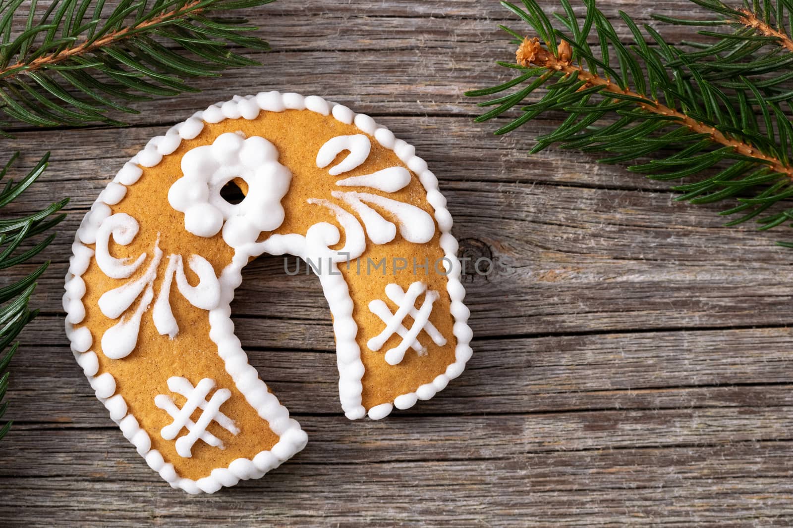 Christmas gingerbread cookie and spruce branches on a wooden background with copy space