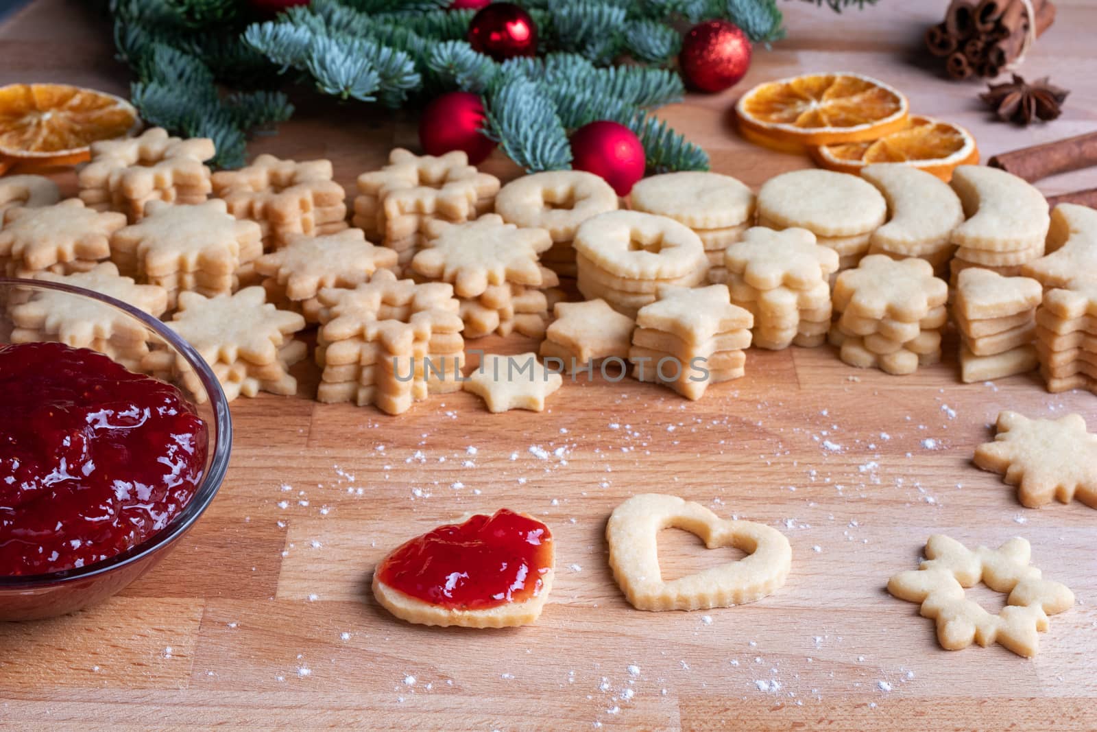 Filling Linzer Christmas cookies with strawberry jam