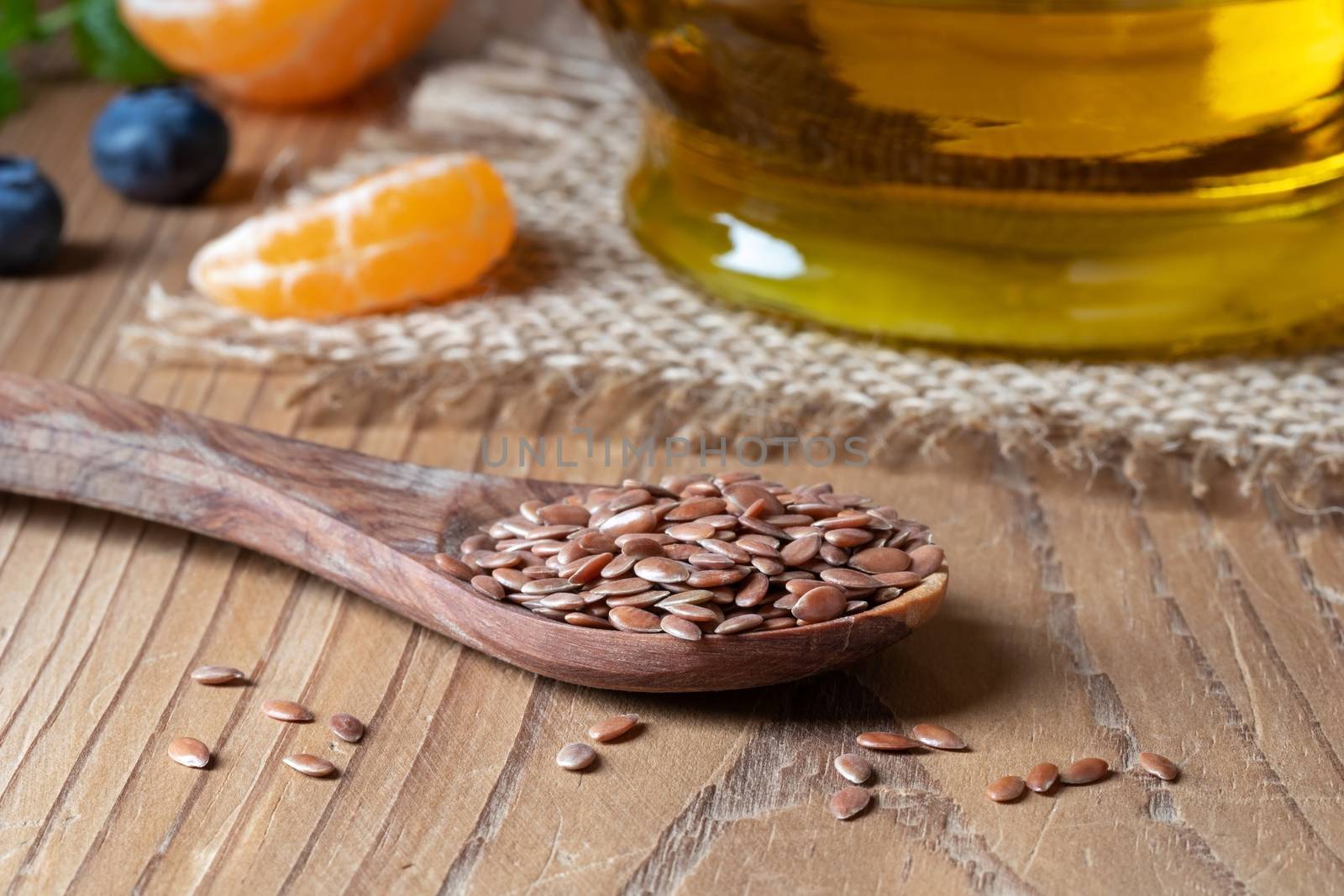 Flax seed on a spoon and oil in the background