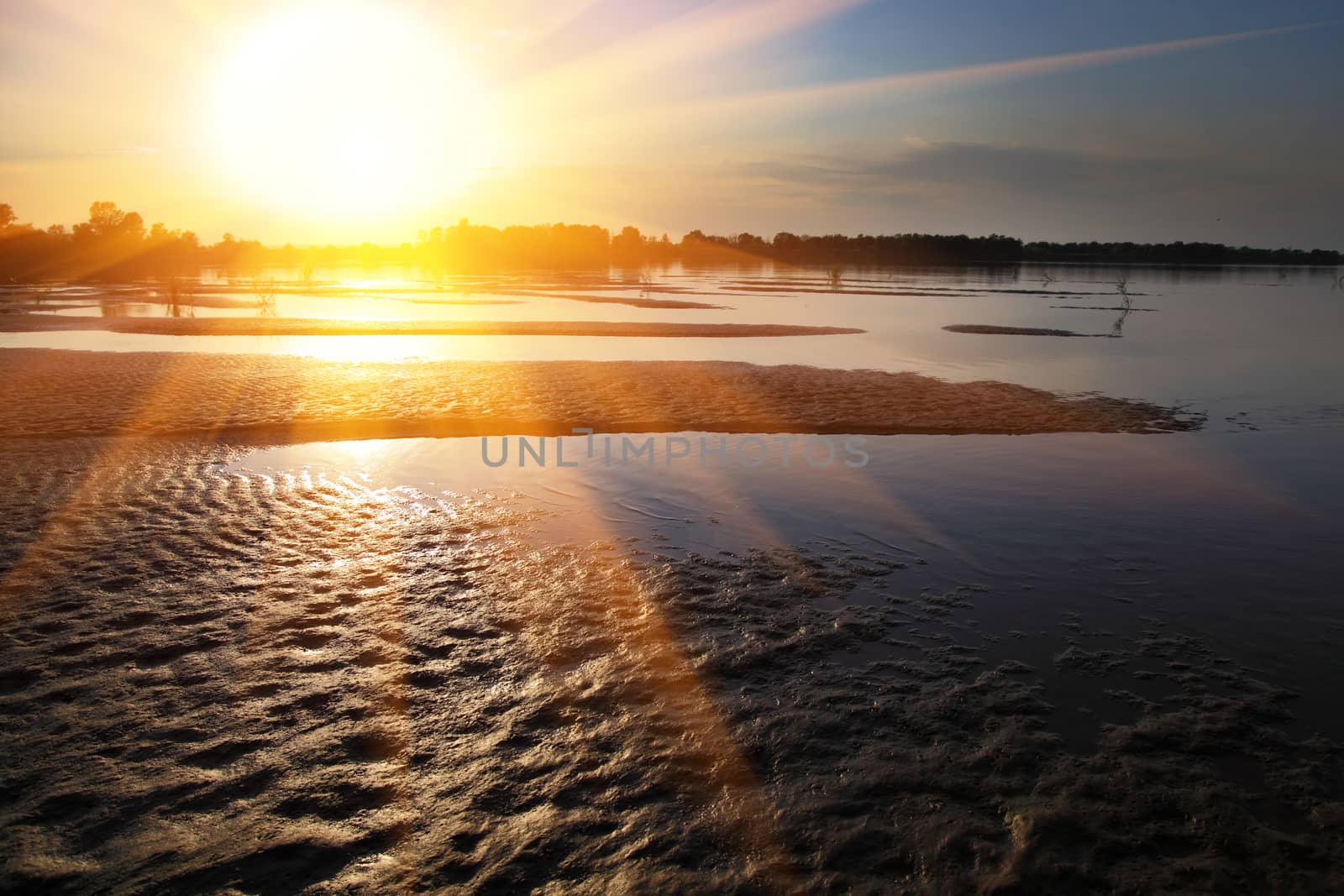 The sandy coast at the river at sunset