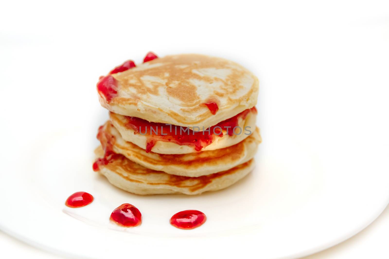 Pancakes with strawberry jam white plate. Selective focus