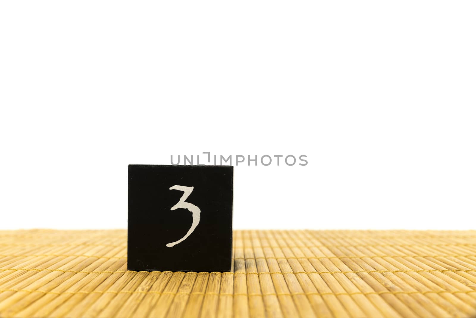 black number 3 block on bamboo underground and with isolated white background