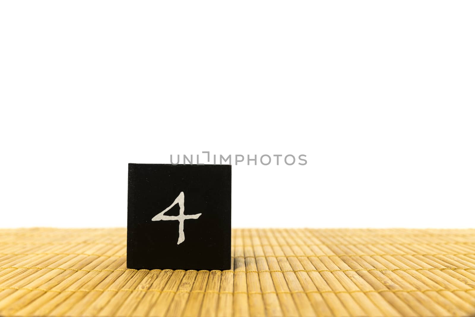 black number 4 block on bamboo underground and with isolated white background