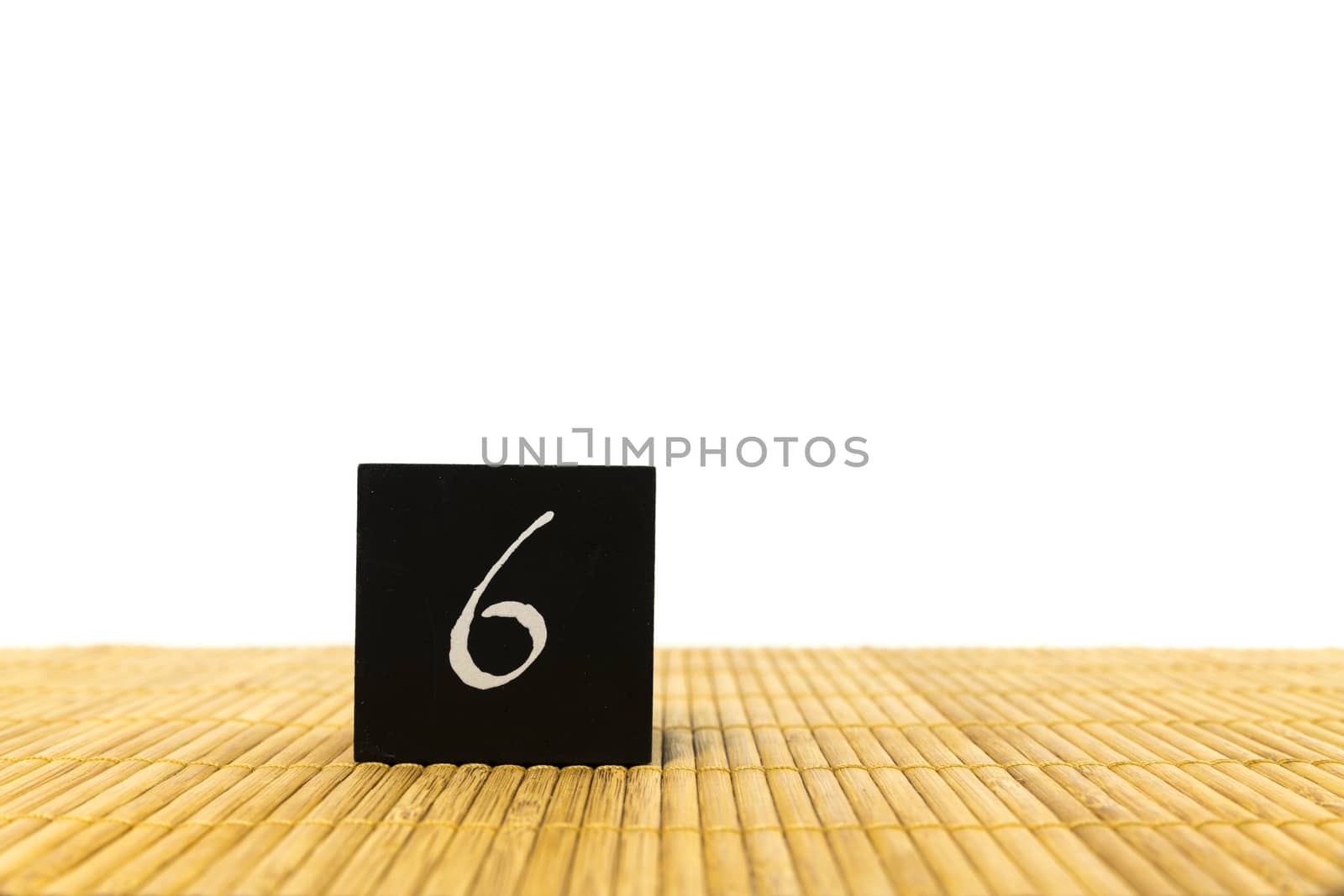 black number 6 block on bamboo underground and with isolated white background