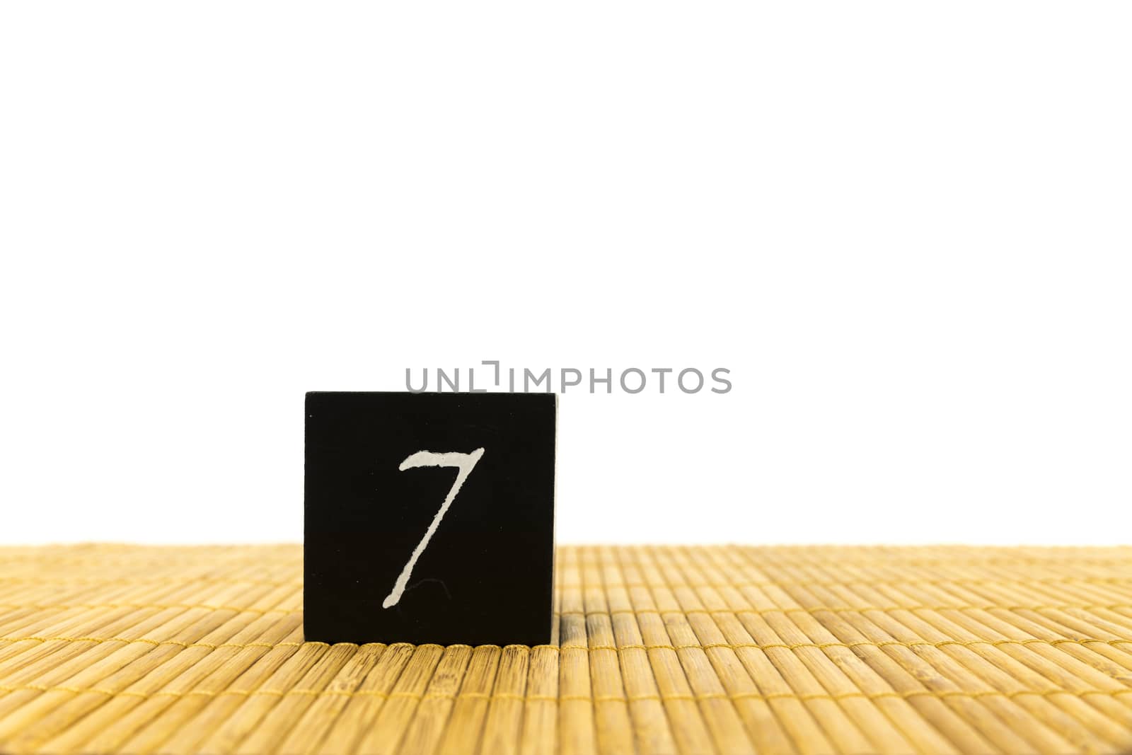 black number 7 block on bamboo underground and with isolated white background