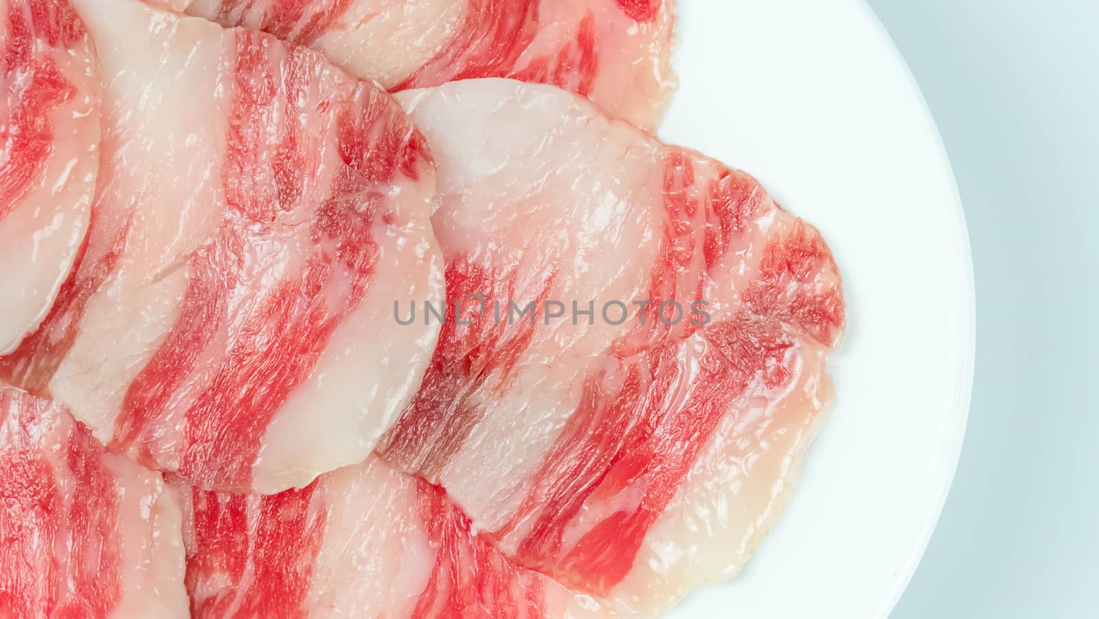 Top view of some raw beef on a plate over white background