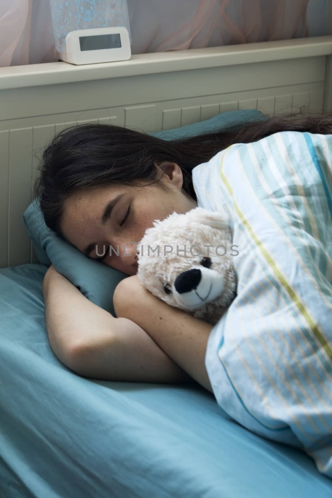 Teenage girl in bed at home caught cold, feeling bad, sleeping. by Anelik