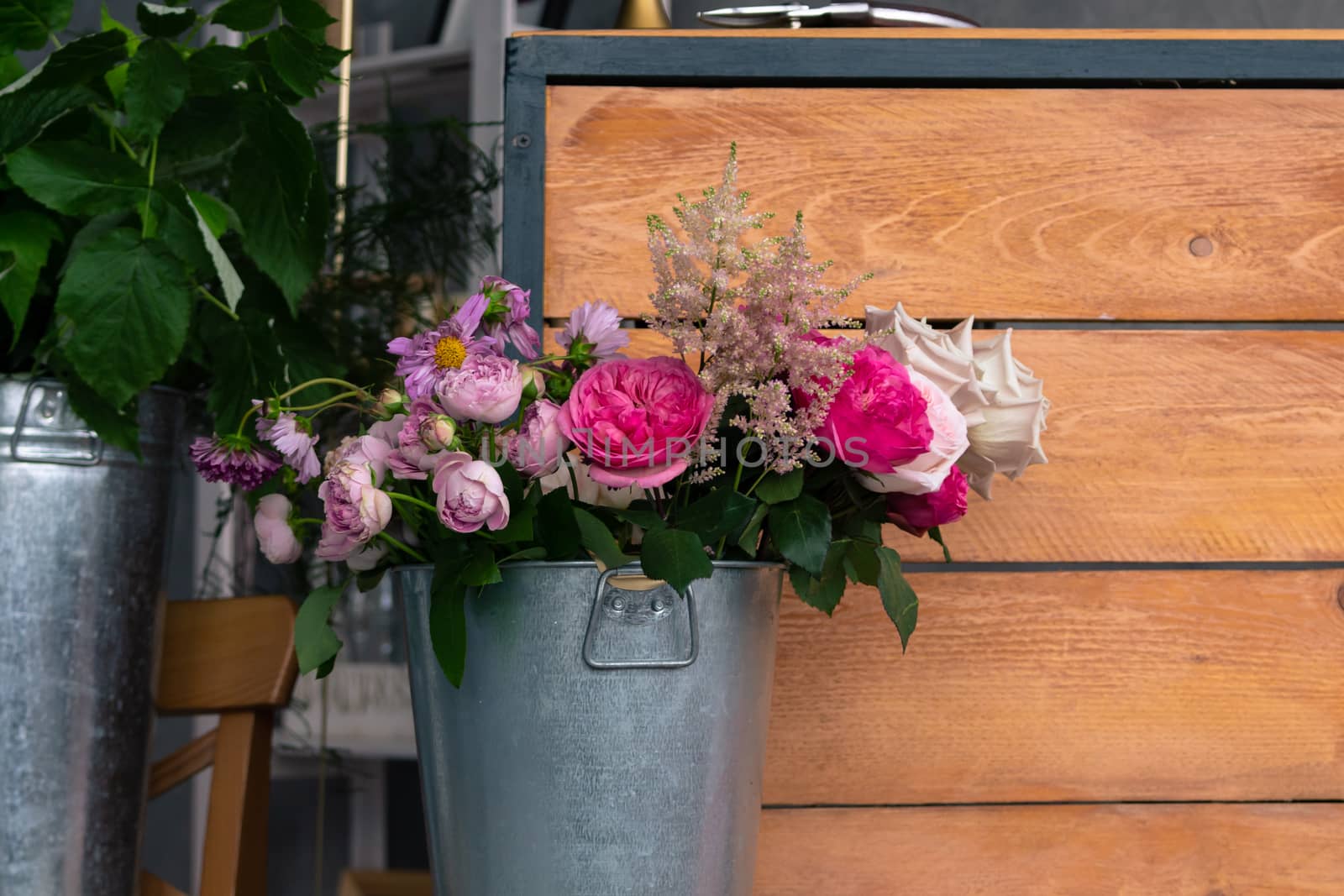 The workplace of the florist to work. Side view. Making floral decorations. Flowers on a old wooden table. Tools and accessories florists need for making up a bouquet. by rdv27