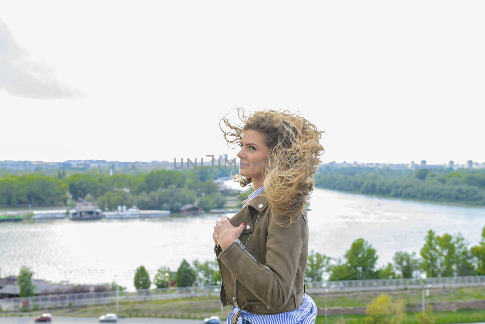 Beautiful long haired woman enjoying the landscape view on a windy cloudy day