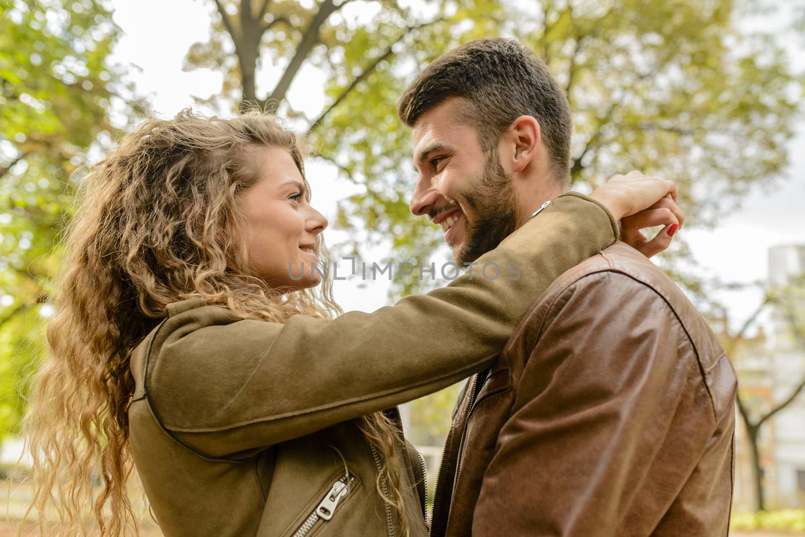 Young couple showing love in the city park by VeraAgency