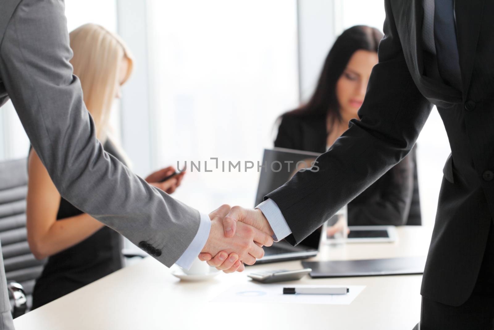 Business people shaking hands finishing up a meeting close up view