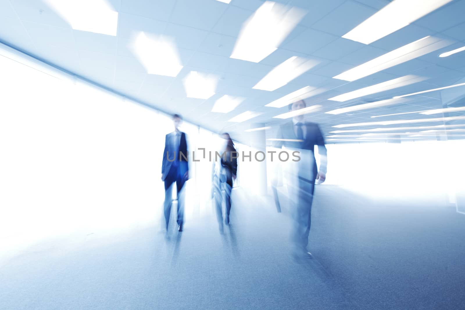 Blurred image of business people walking together in office