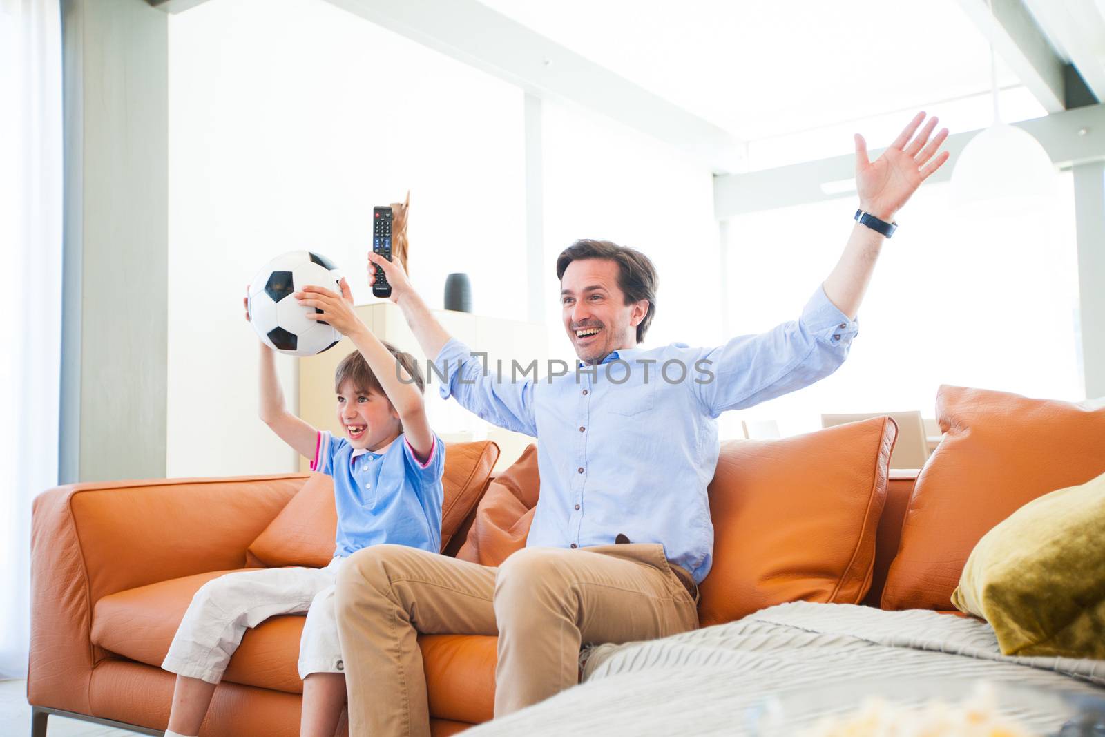 Boy watching soccer match with father by ALotOfPeople