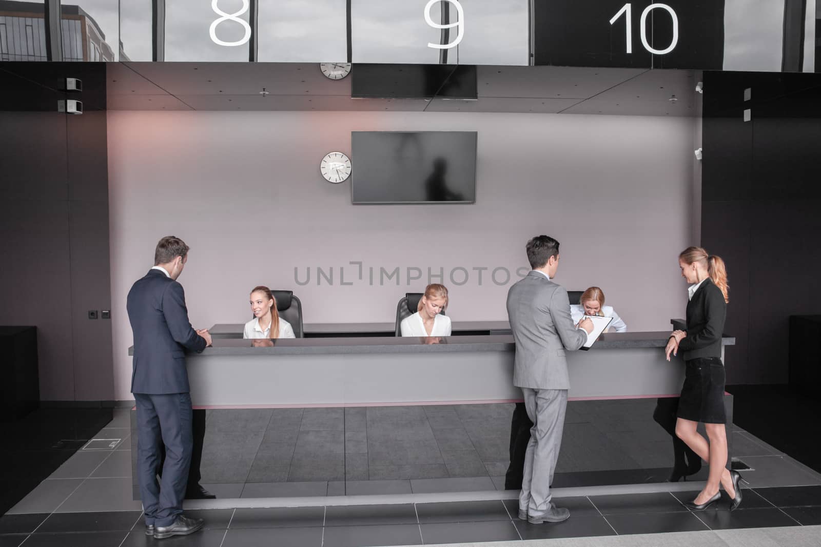 Business people at reception or front desk in office building, hotel or airport