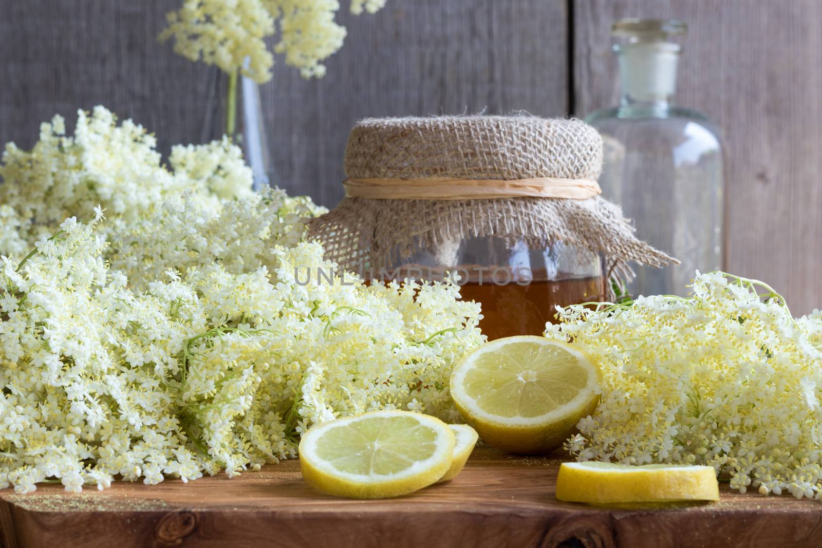 Fresh elder flowers on a wooden background with honey and lemon