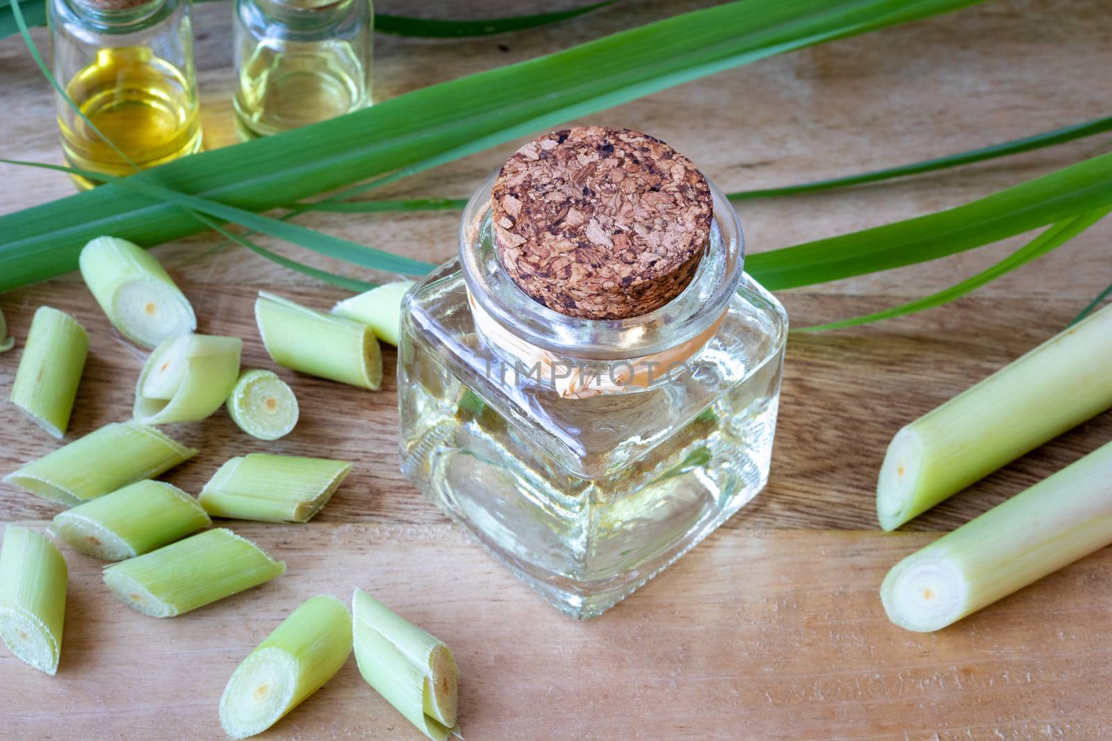 A bottle of essential oil with fresh lemon grass