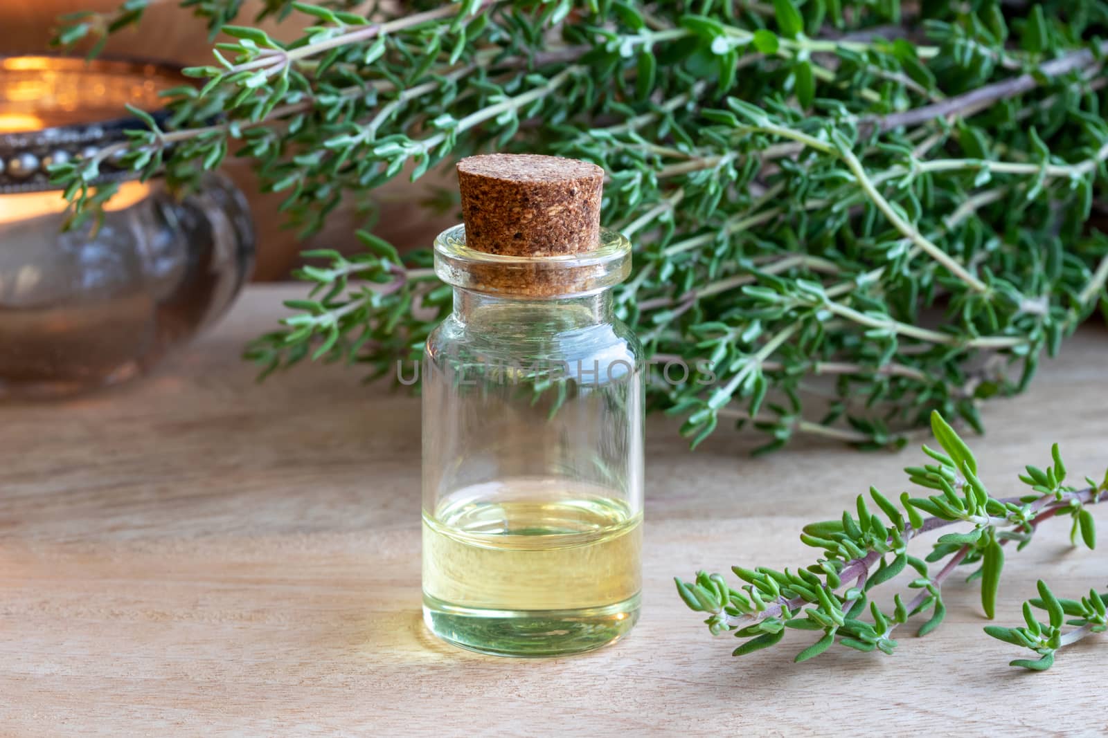A bottle of essential oil with fresh thyme twigs
